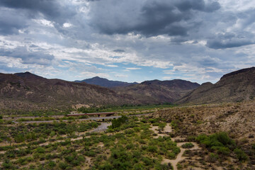 Panoramic dramatic clouds over the mountains are a desert cactus mountain landscape near the highway in Arizona