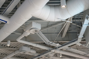 Ventilation system under ceiling of modern warehouse or shopping mall. Metal piping for air conditioning