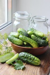 Fresh cucumbers on a wooden table. Dill, garlic and spices. Preparation of pickled cucumbers....