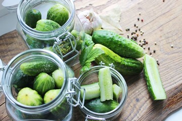 Cooking fresh pickled cucumber on a wooden table. Homemade pickles with dill and garlic in a jar....