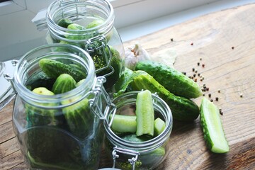 Cooking fresh pickled cucumber on a wooden table. Homemade pickles with dill and garlic in a jar. Canned cucumbers, pickled cucumbers