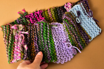 a piece of hand knitting fabric in multi colours 