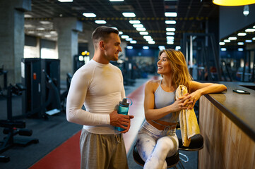 Sportive couple relax at the counter in gym bar