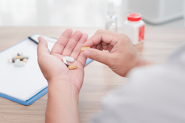 A man holding vitamin in hand to prevent illness from viral infection : home isolation healthy care concept medicine, nutritional supplements and people concept