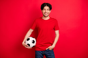 Photo of young sportive man happy positive smile hold soccer ball play football game isolated over...