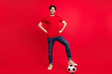 Full length photo of young man happy positive smile play football game sportive isolated over red color background