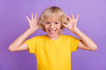 Photo of foolish funny funky blonde kid boy have fun wear yellow t-shirt isolated violet color background © deagreez