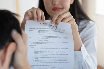 Close-up view of employee tearing a contract paper.