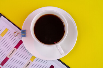 Top view white cup of strong coffee and paper binder.