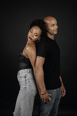 latin couple back to back and eyes closed. Posing on black background. Concept trust and censorship