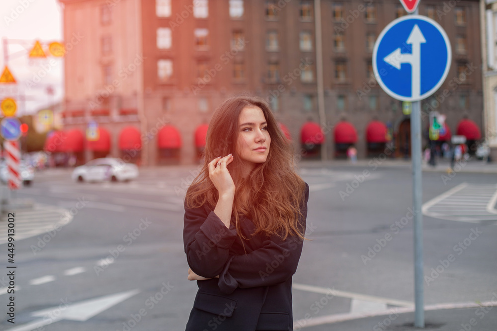 Wall mural Young beautiful brunette woman walking in the street in city centre at sunrise time