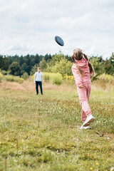 Children brother and sister play with a plastic plate frisbee - active games without smartwon and...