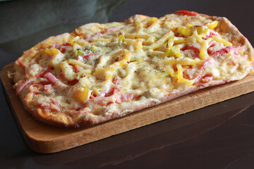 pizza with cheese and tomatoes on a wooden stand
