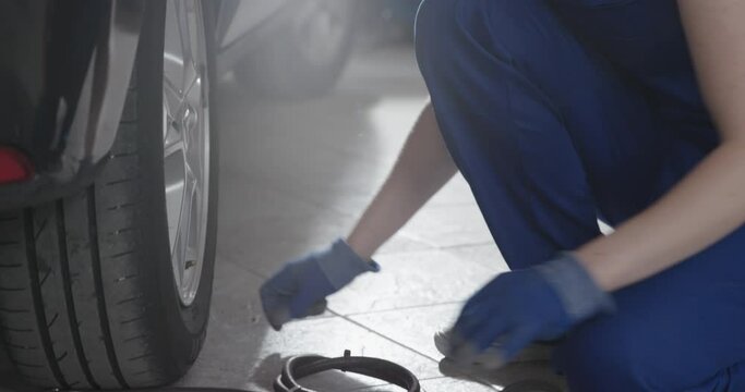 Female mechanic checking tire pressure