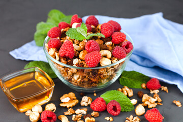 A bowl of granola with fresh raspberries and honey for breakfast. Healthy food concept. Making homemade granola. ?lose-up.