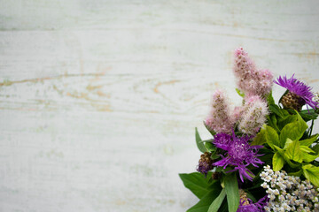 A bouquet of wild flowers on a wooden background. Rustic style. Copy space