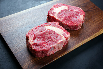 Modern Style rohes dry aged Wagyu Rib-Eye Beefsteaks angeboten als close-up Design Holz Board