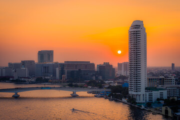Aerial view Bangkok city Overview of high and low buildings in the capital, have the large river, house, Office building and condominiums during the evening with red sunset the sky Cityscape Thailand