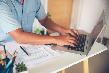 Hand of man using laptop. Personal income tax return form under US law placed on desk. Accountant work annual budget and tax on computer, Work from home. Annual Budget and Tax planning concept