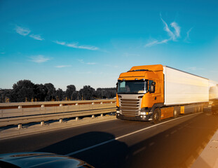 Orange lorry truck on the road, at sunset, motion blur. © phoenix021
