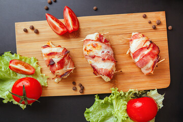 Baked chicken wrapped in bacon. Delicious appetizer with crispy smoked bacon. Chicken breast...
