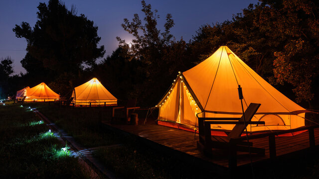Glamping at night, few glowing tents