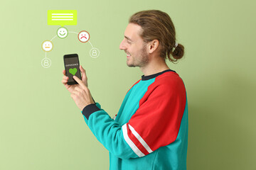 Young man giving rating to new mobile application on color background