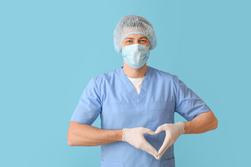 Cardiologist making heart with his hands on color background