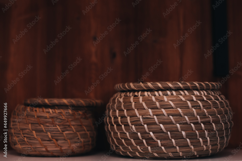 Wall mural Two small wicker baskets on the wooden shelf. Kitchenware