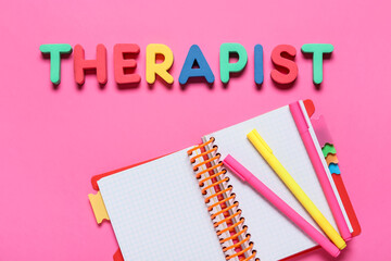 Word THERAPIST with notebook and markers on color background