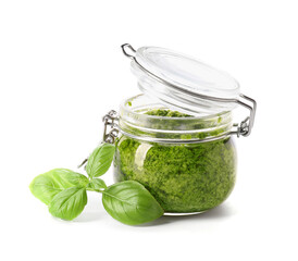 Jar with fresh pesto sauce and basil leaves on white background