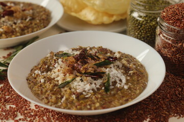 Porridge or gruel made of Navara rice, mung beans and fenugreek seeds sprinkled with fresh grated...