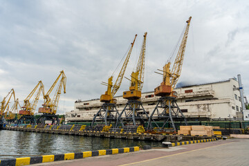 Fototapeta na wymiar Sea port with yellow working cranes in Ukraine