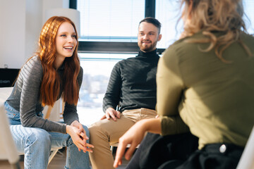 Close-up of successful young redhead businesswoman talking and discussing new ideas with creative...