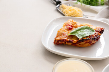 Plate with tasty vegetable lasagna and sauce on light background, closeup