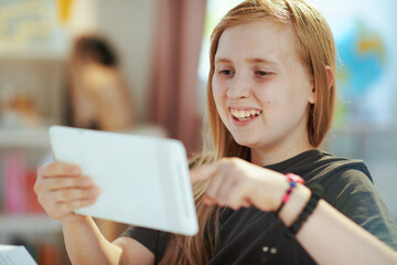 smiling school girl distance learning at home in sunny day