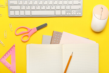 Notebook with stationery and computer keyboard on color background