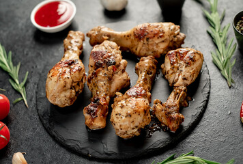grilled chicken legs with spices on a stone background