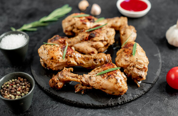 grilled chicken legs with spices on a stone background