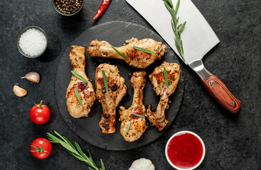 grilled chicken legs with spices on a stone background