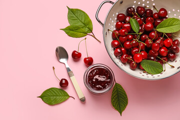Jar of tasty cherry jam on color background