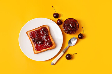 Bowl and toast with cherry jam on color background
