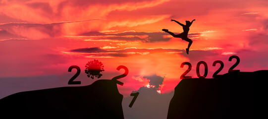 New Year 2022, Young woman jumping across the gap of the mountain.