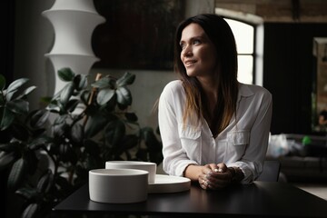 Confident stylish european middle aged woman sitting at cafe, 30s lady executive leader manager looking at camera.