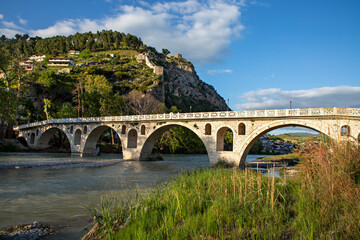 Fototapeta na wymiar Historical arched bridge over the Osumi River in Berat, Albania
