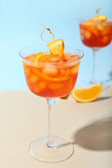 Glasses of Aperol spritz cocktail on color background