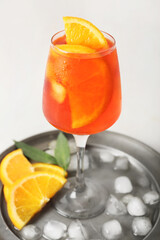 Glass of Aperol spritz cocktail on light background