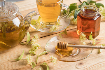 The concept of phyto and aromatherapy.Linden flower tea and linden honey on a light wooden background.