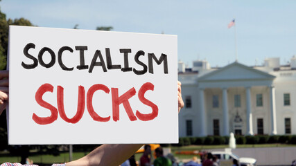 WASHINGTON, DC - Circa August, 2021 - A man holds a handmade SOCIALISM SUCKS protest sign outside...