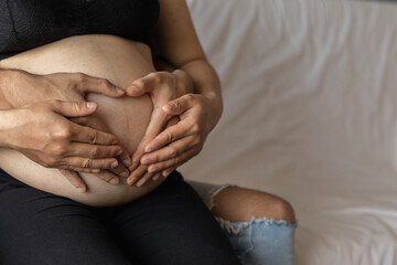 A pregnant woman and her boyfriend put their hands on the womb to show their love for the unborn...